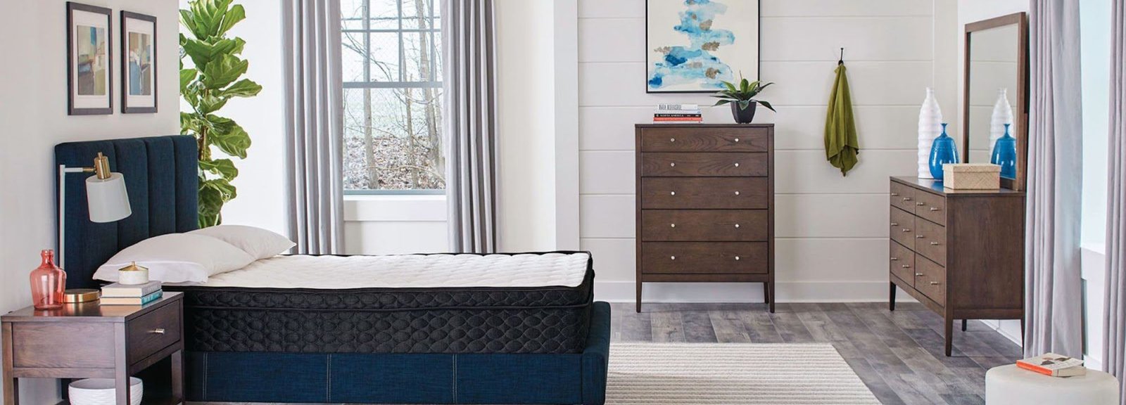 Hybrid mattress on an upholstered navy bed frame